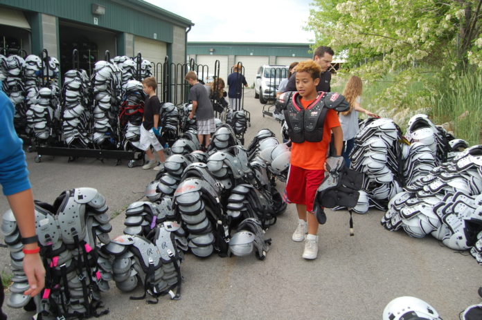 Tazen Selu stacks football shoulder pads by size